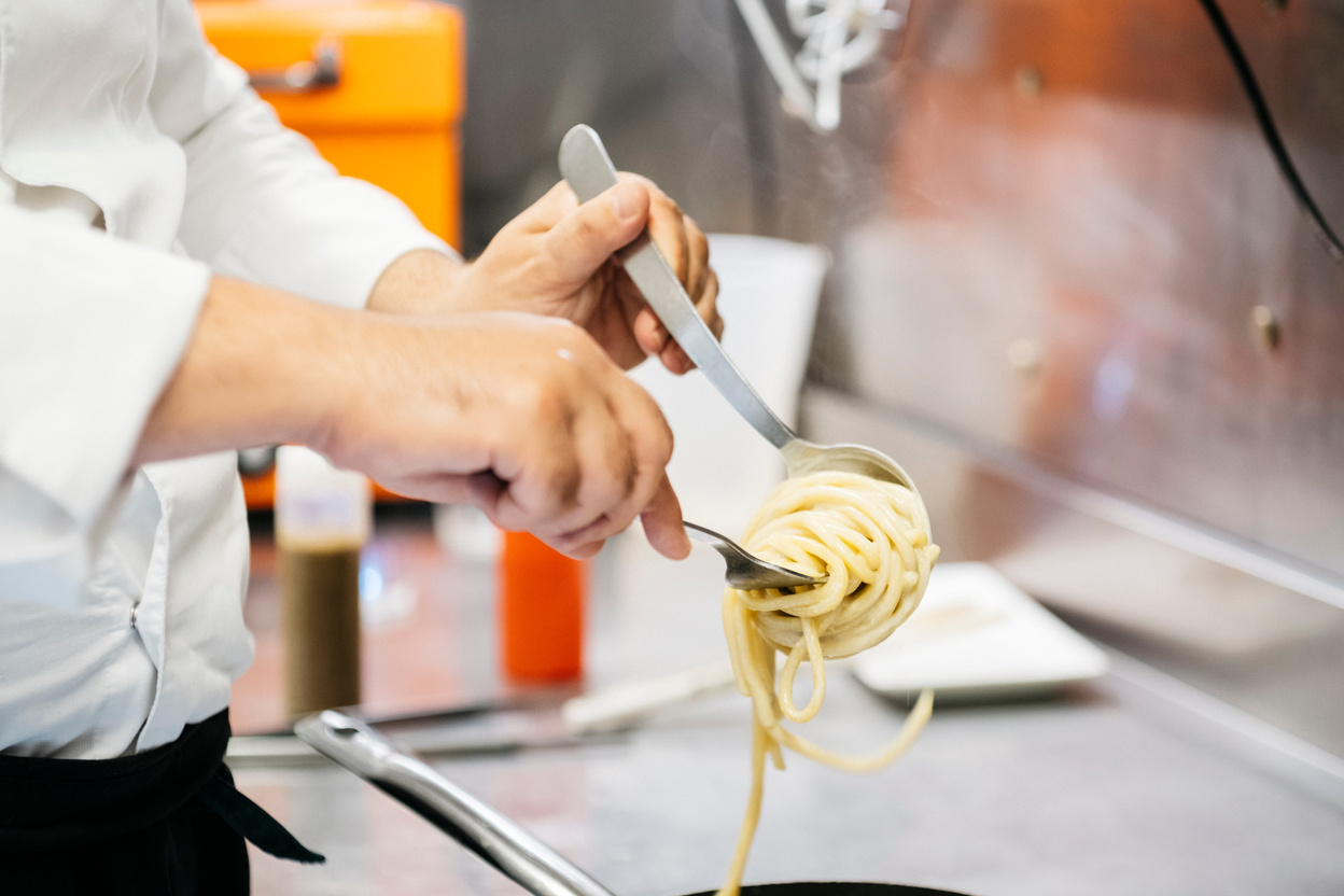 Preparazione spaghetti di gamberi a cura di uno chef in un ristorante