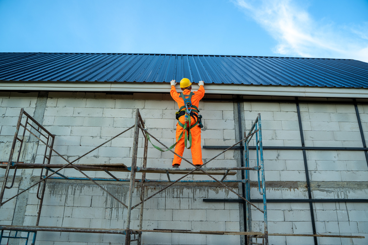 Working at height equipment,Construction worker wearing safety harness belt during working on roof structure of building.
