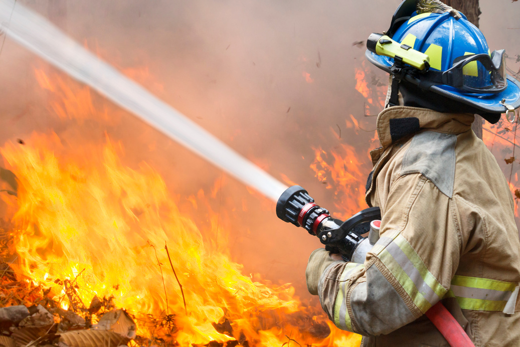 Firefighter Hosing a Wildfire